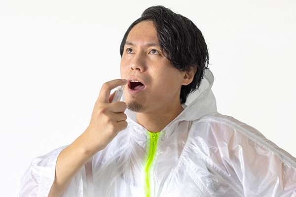 市販の口臭抑制商品を使用する男性